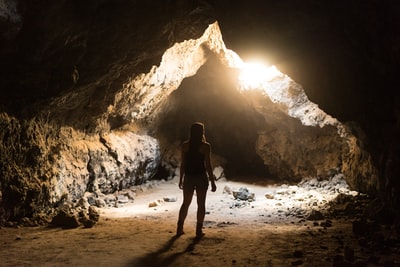 女人站在洞穴
